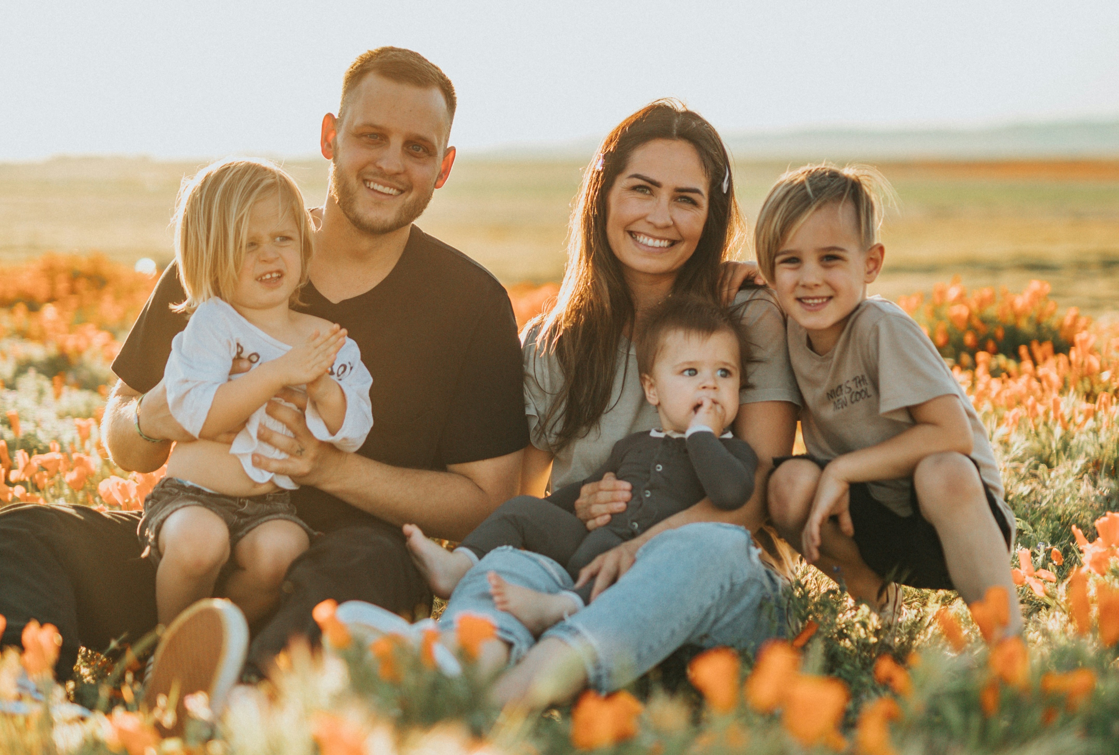 A picture of a happy family outside in a sunny field